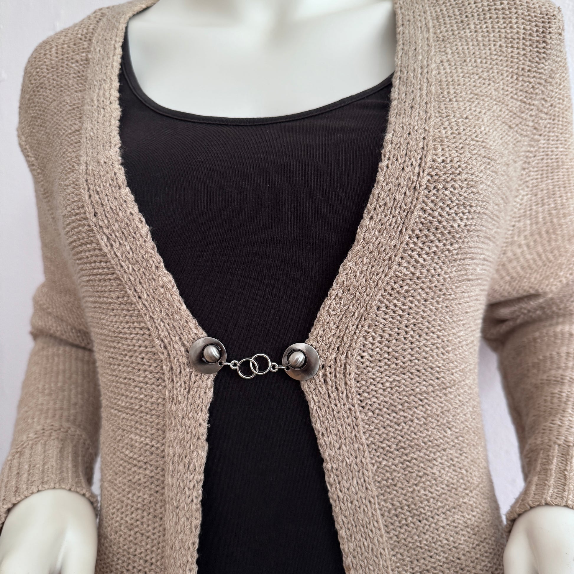 Vestsluiting Het Houvastje gedragen op een gebreid vest, elegante Fashionclip met zilverkleurige clips en dubbele ringverbinding.