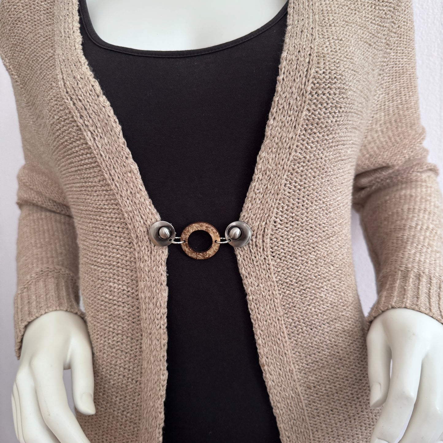 Vestsluiting Kokosnoot zilver gedragen op een beige gebreid vest, elegante Fashionclip met zilverkleurige clips en natuurlijke kokosring.