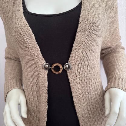 Vestsluiting Kokosnoot zilver gedragen op een beige gebreid vest, elegante Fashionclip met zilverkleurige clips en natuurlijke kokosring.